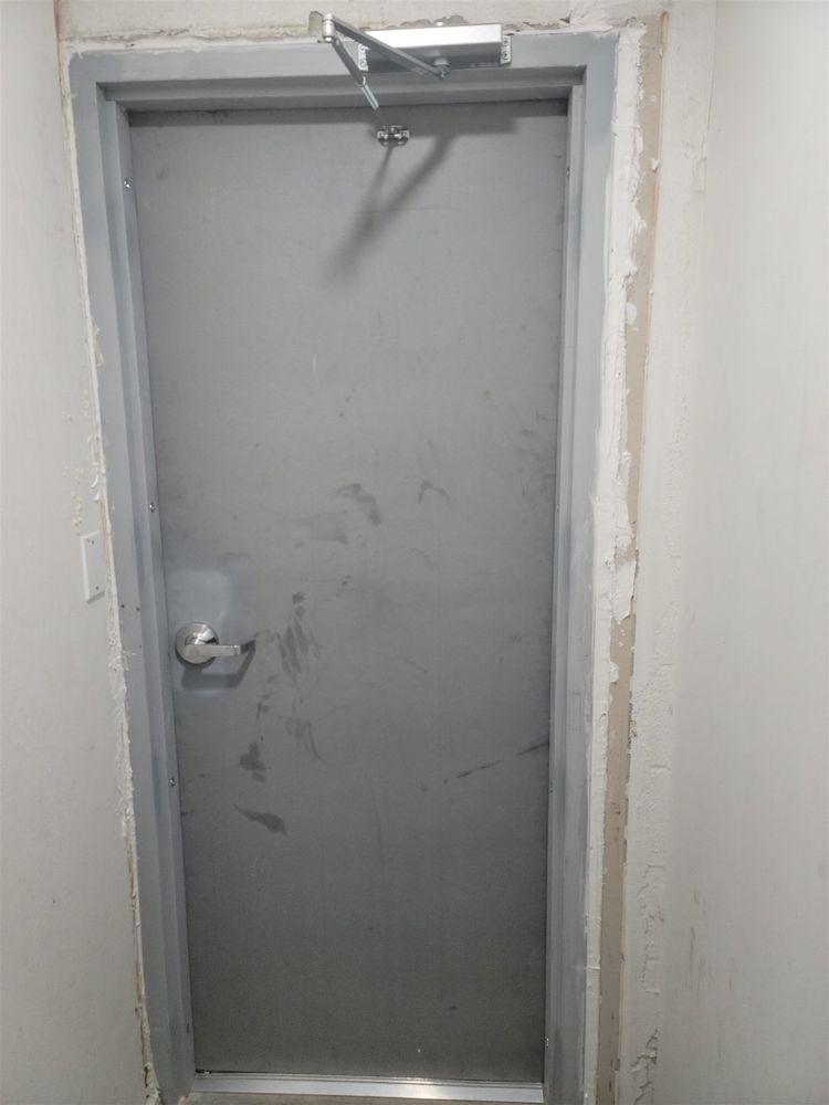 Scuffed steel service door in an unfinished frame