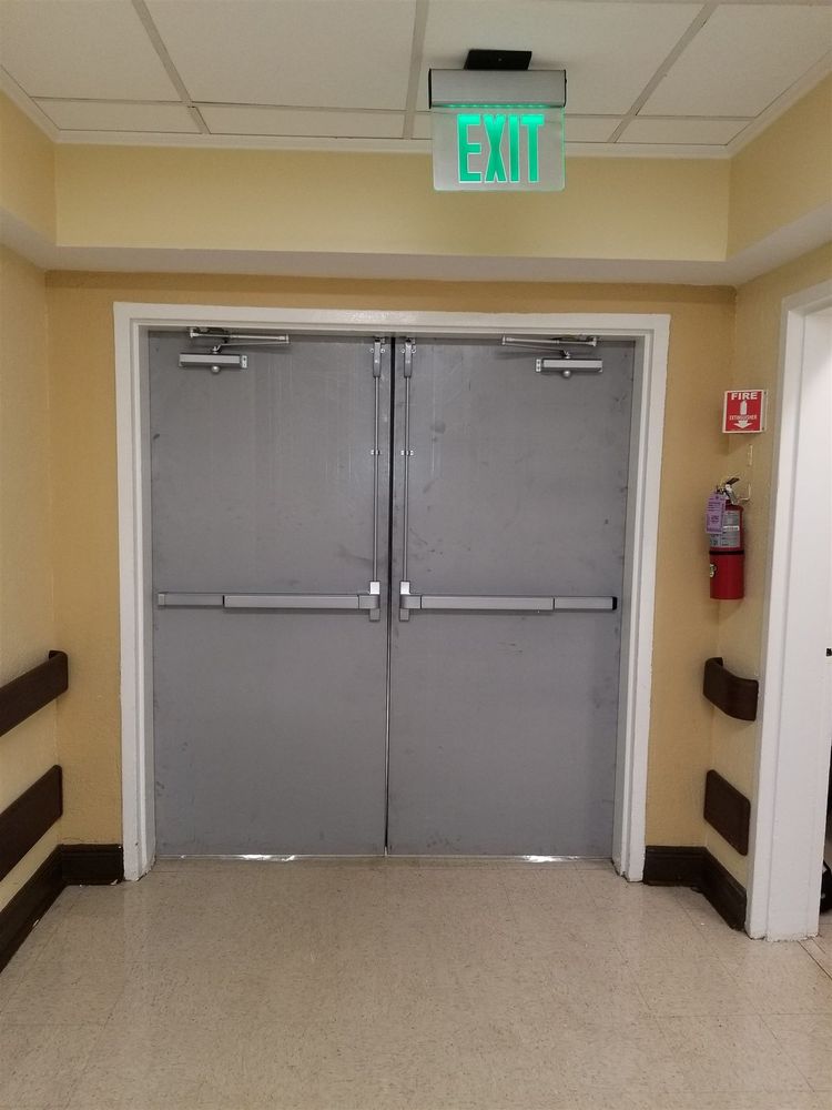 Corridor pair of steel doors with panic hardware under an exit sign