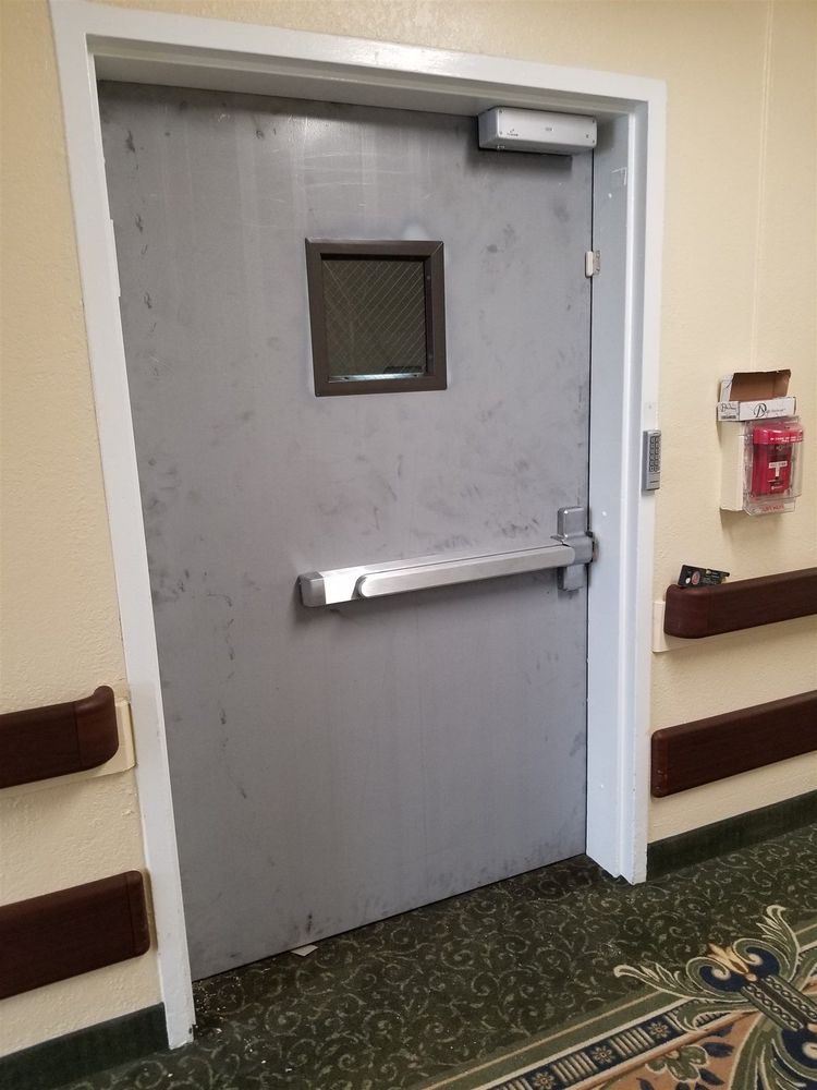 Steel door with vision lite and panic bar in a carpeted corridor