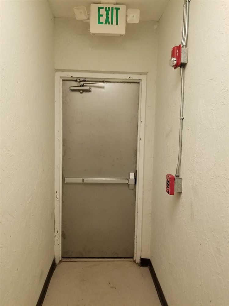 Hallway exit door with panic bar under an exit sign