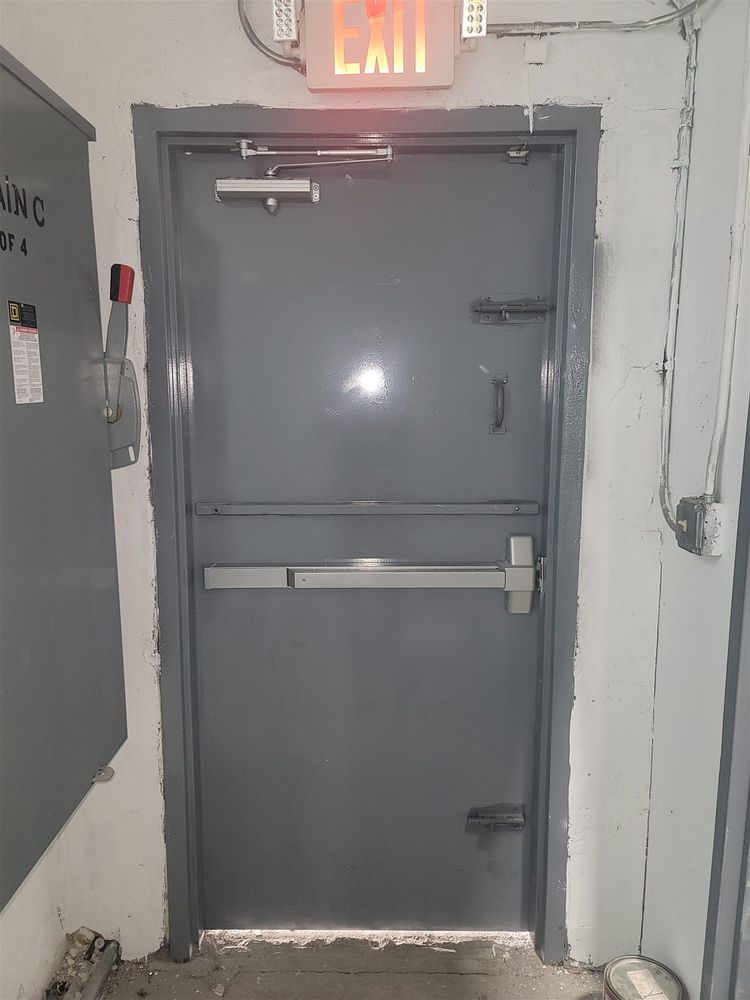 Steel exit door with panic bar and closer under a lit exit sign
