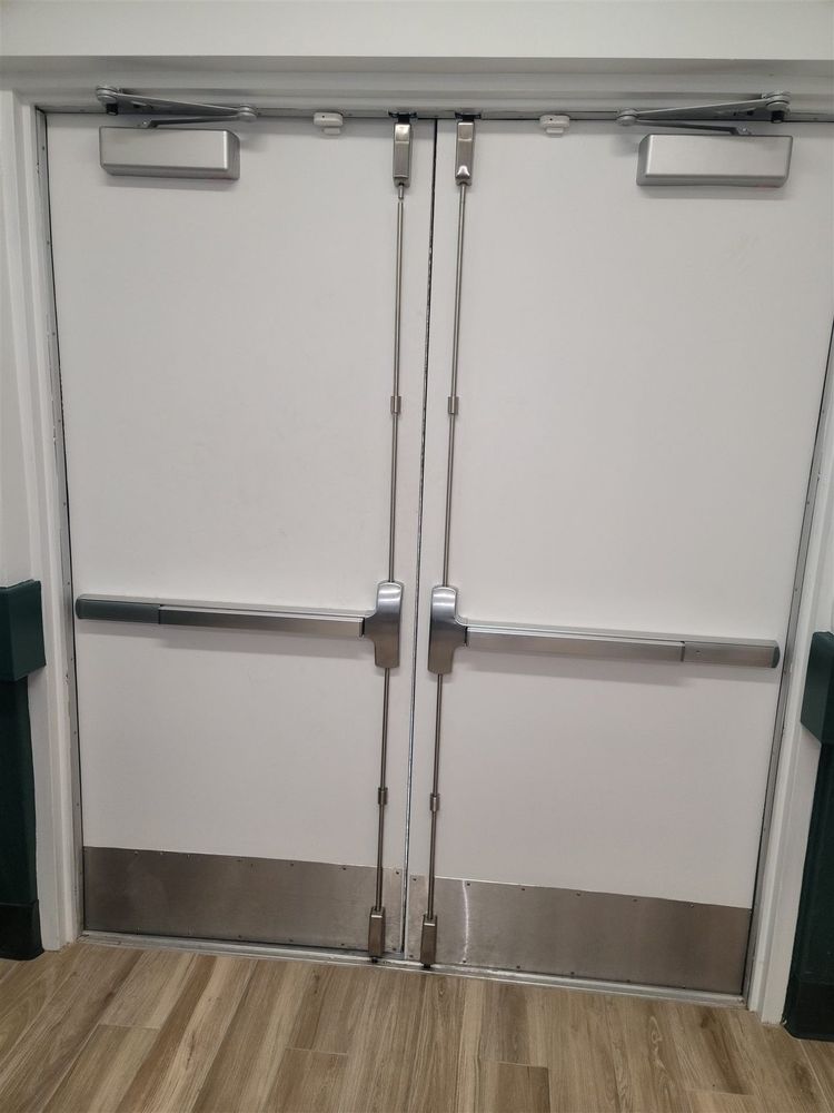 White steel double doors with panic bars and kick plates