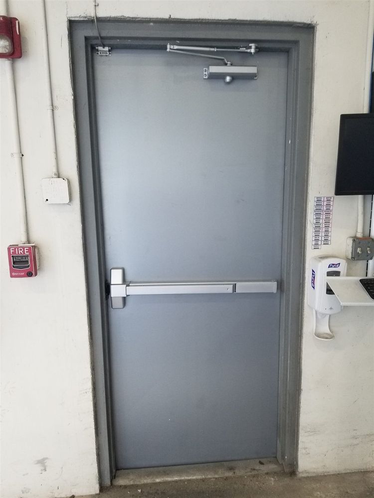 Tall hollow metal exit door with panic bar and closer