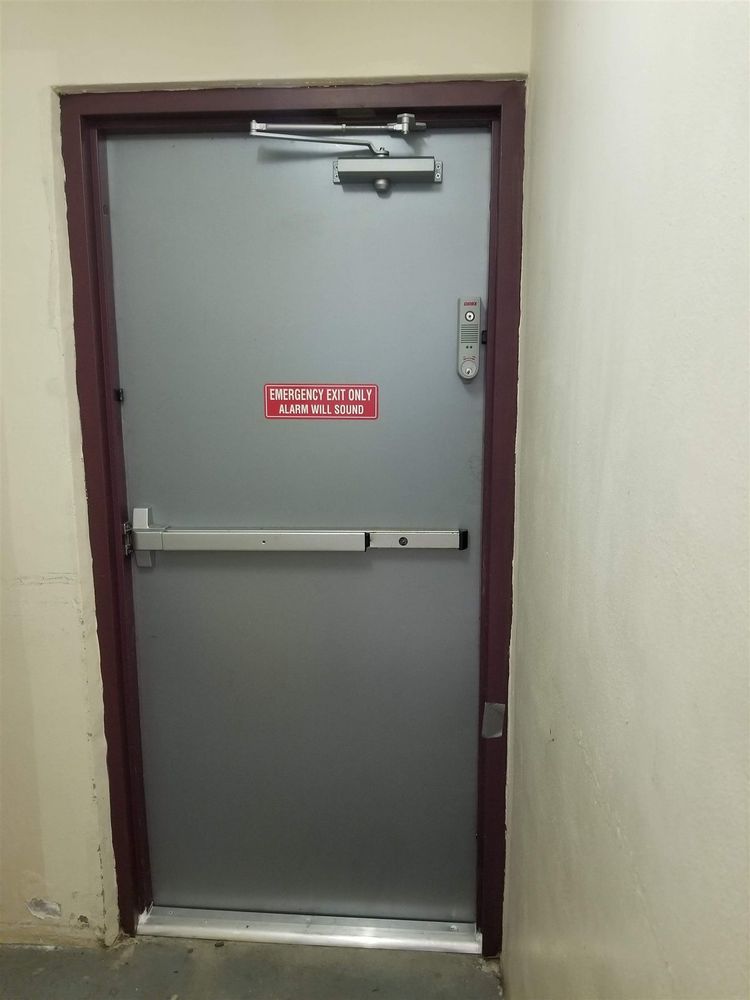 Hollow metal door with panic bar in a dark red frame