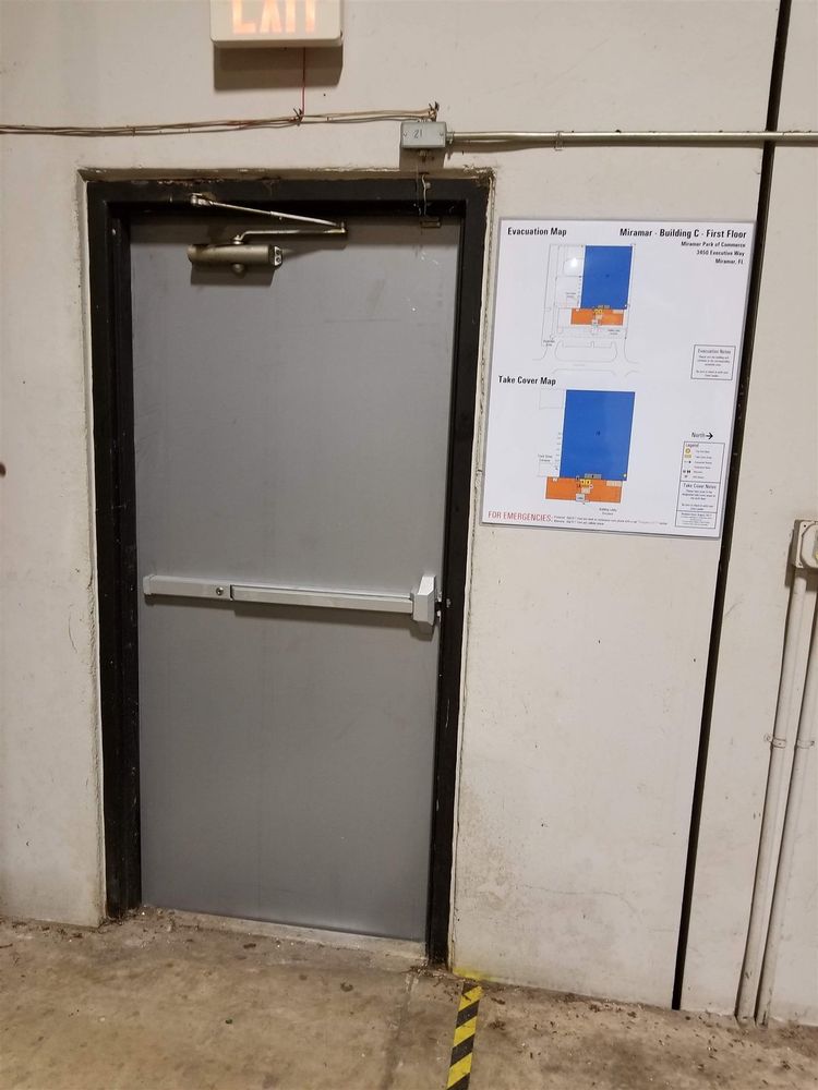 Steel exit door with panic bar in a black frame