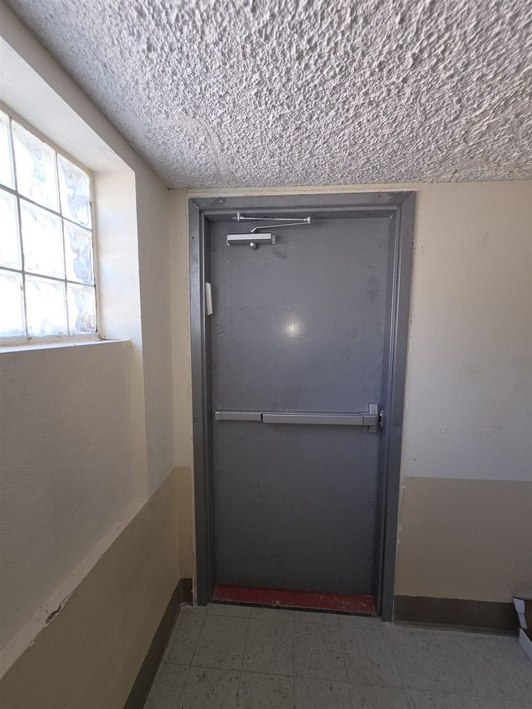 Steel stairwell exit door with panic bar and closer