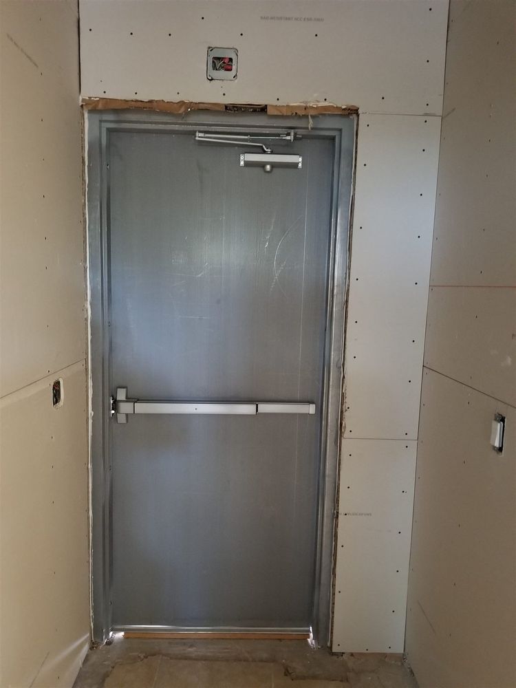 Hollow metal exit door with panic bar and closer