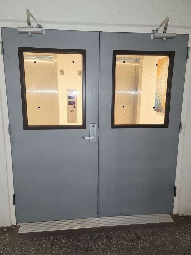 Gray pair of hollow metal doors with vision lites and closers