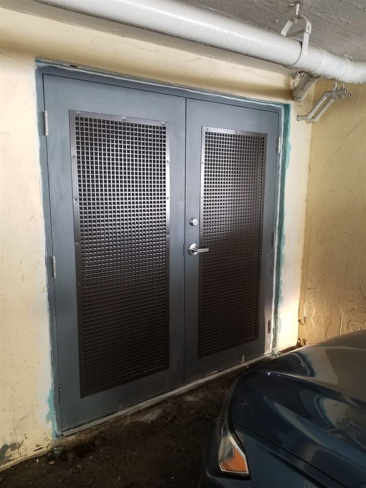 Pair of hollow metal doors with grille vents in a parking garage