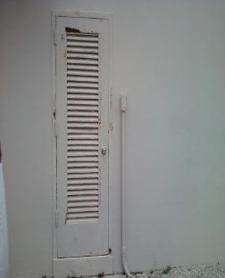 Damaged louvered metal utility door