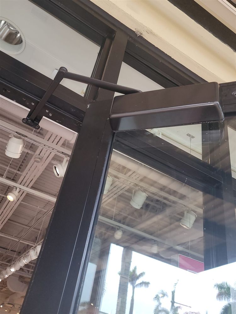 Door closer arm on a storefront door frame