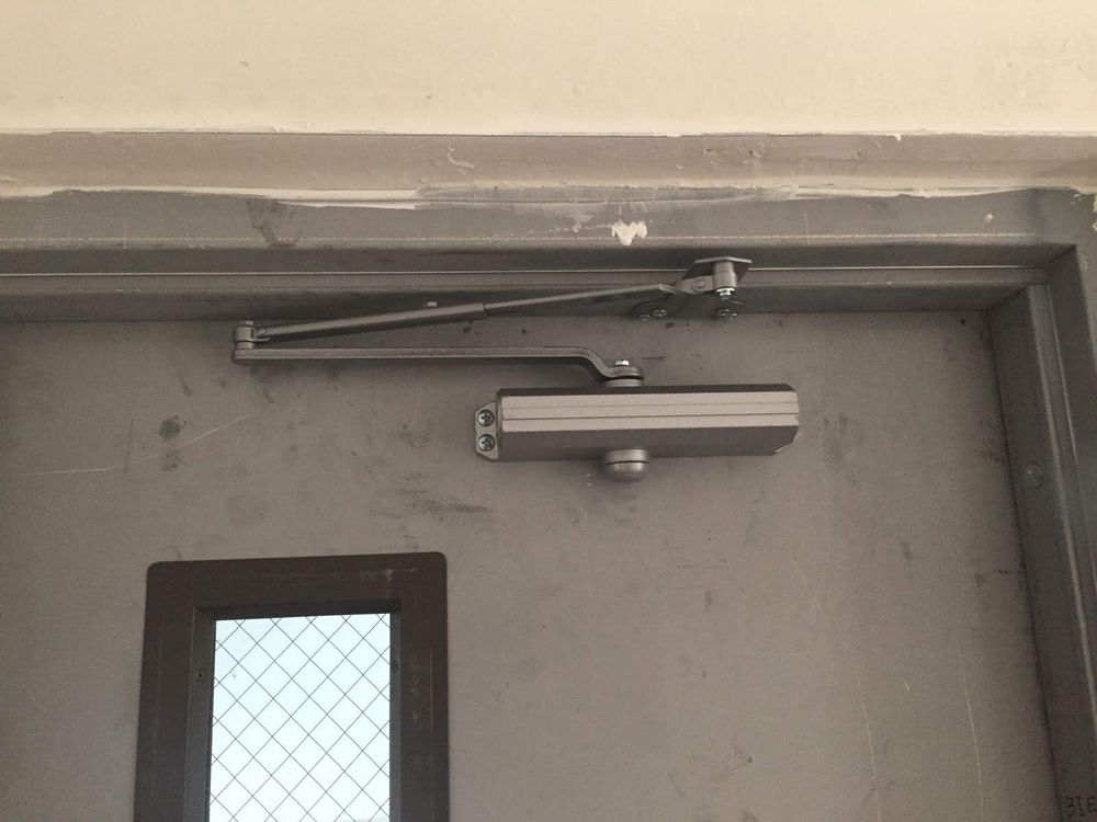 Surface-mounted door closer on a steel door
