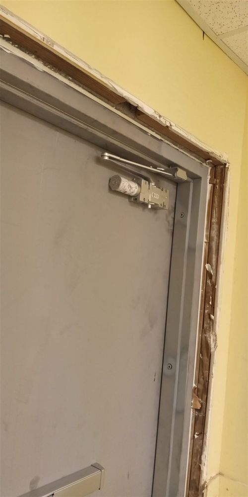 Door closer on a steel door being installed in a frame