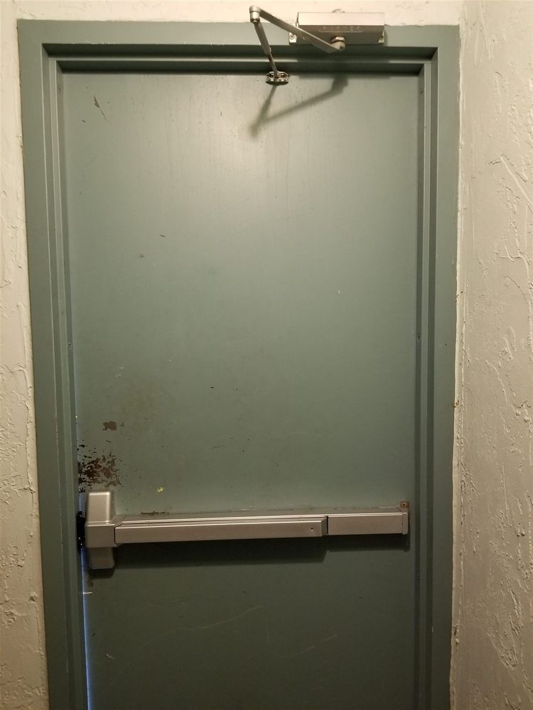 Green steel door with a panic bar exit device