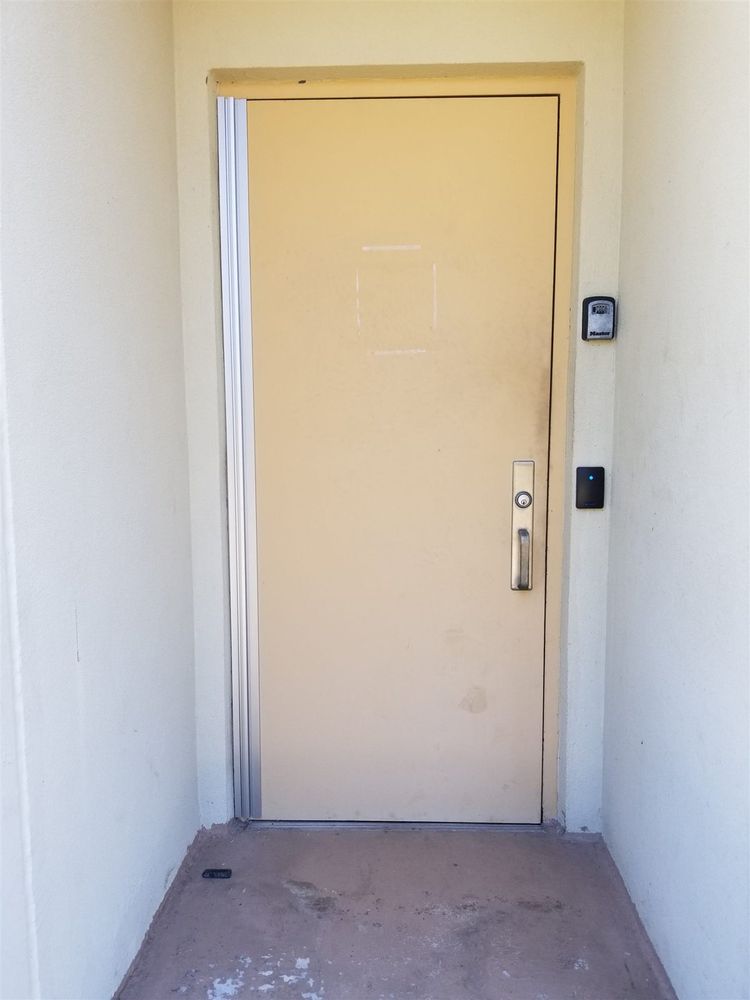 Tan commercial steel door with a full-height continuous hinge, pull handle and card reader