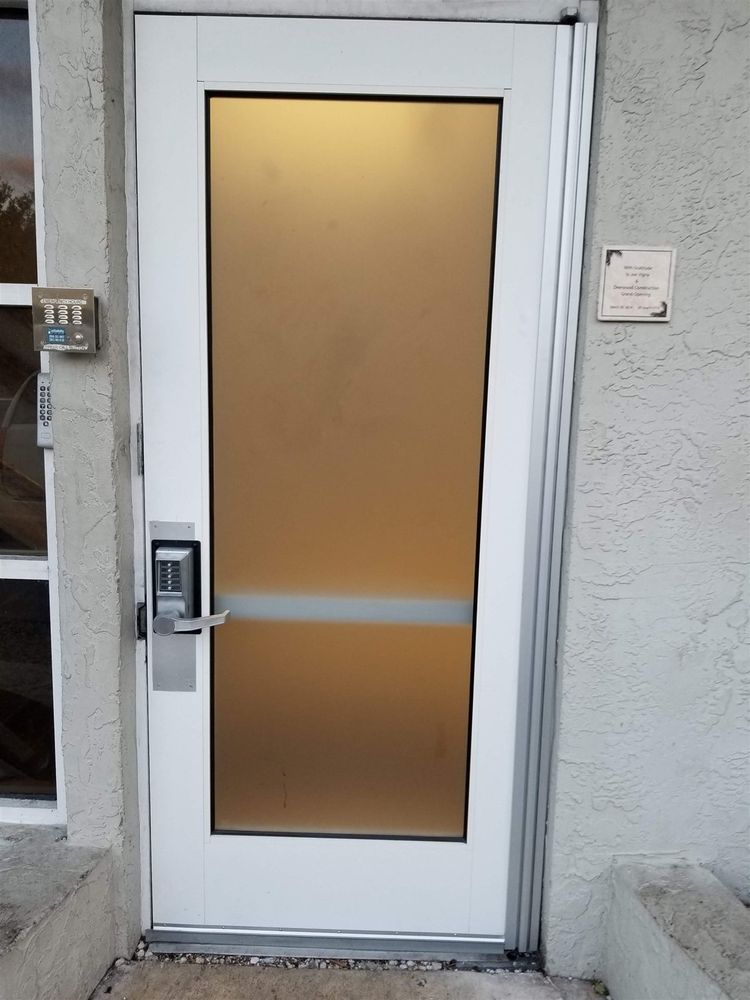White frosted-glass commercial door with a continuous hinge and keypad lever lock