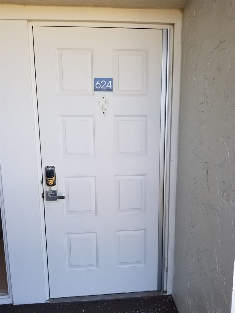 White apartment unit door with a continuous hinge and keypad deadbolt
