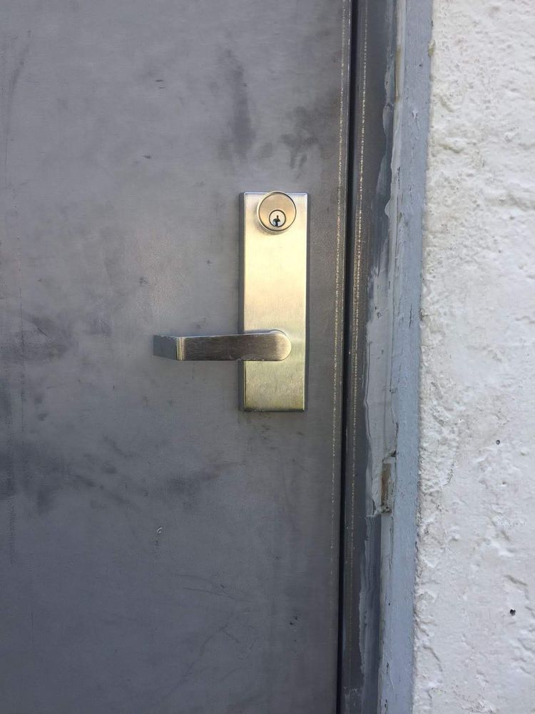 Commercial lever lock with key cylinder on a steel door
