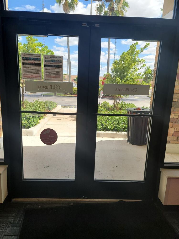 Dark aluminum storefront doors hung on pivots
