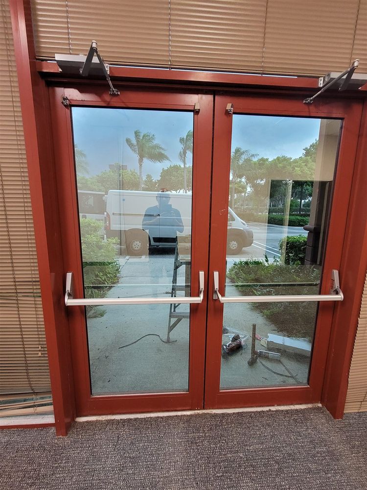 Red-framed aluminum storefront double doors with panic bars