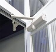 Surface-mounted door closer installed on an aluminum storefront door
